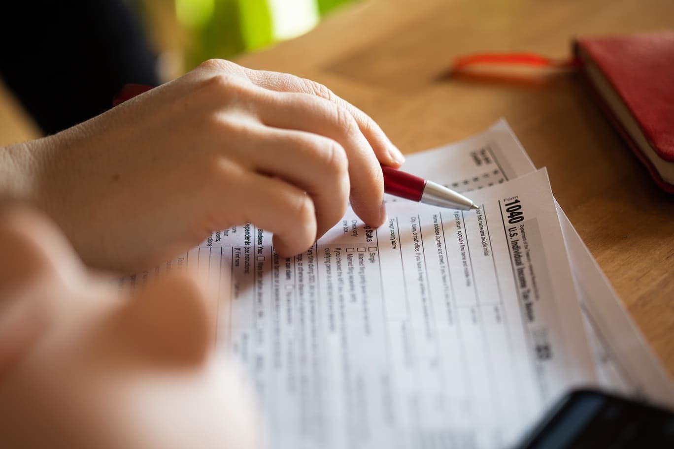 Pen resting on the filing status lines of a Form 1040